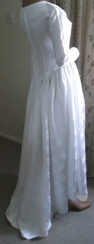 Side and partial back view of the wedding dress showing the train