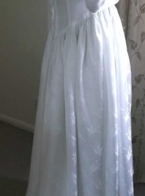 Side and partial back view of the wedding dress showing the train