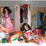 1970s and 80s Sindy dolls search through a messy bedroom to find items to pack in bulging suitcases.