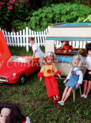 Vintage Sindy dolls stand outside their caravan on a Sindy campsite while Paul unloads a case from the red MG next to an orange tent