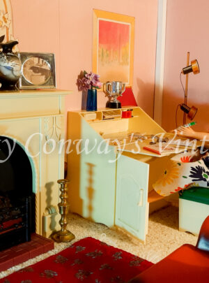 Sindy sits at home at her bureau to write a letter.